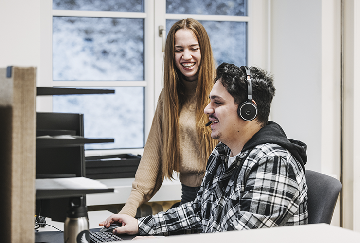 Two Angelbird support team members interacting and sharing a moment in a collaborative workspace.