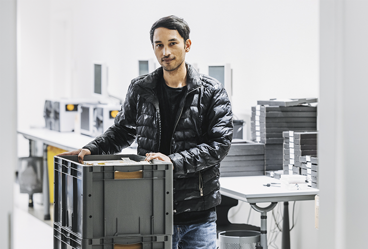 Angelbird collaborator holding a box with company products, preparing for packaging or distribution.
