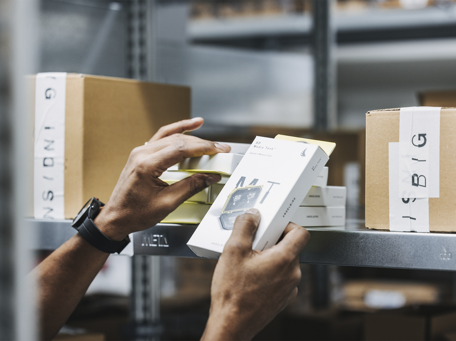Angelbird products on a shelf being handled by one team member